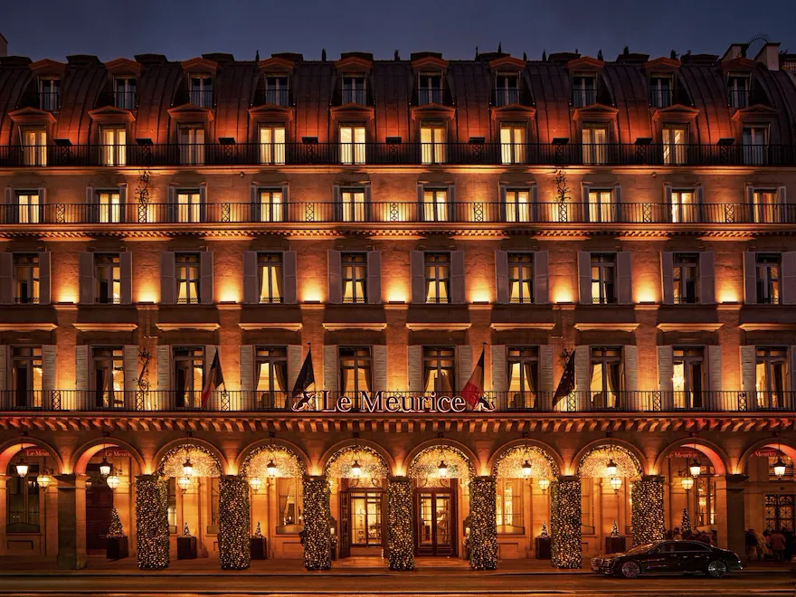 Hotel by night with lights on the facade and Christmas decorations illuminated on the arcades, at Le Meurice, Paris