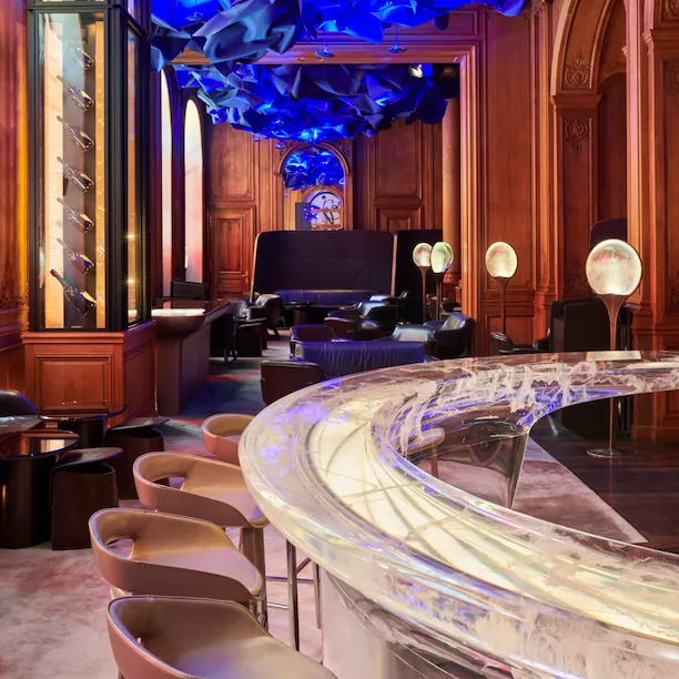 Photo du Bar de l’Hôtel Plaza Athénée, Paris, panneaux de bois, plafond bleu et comptoir transparent