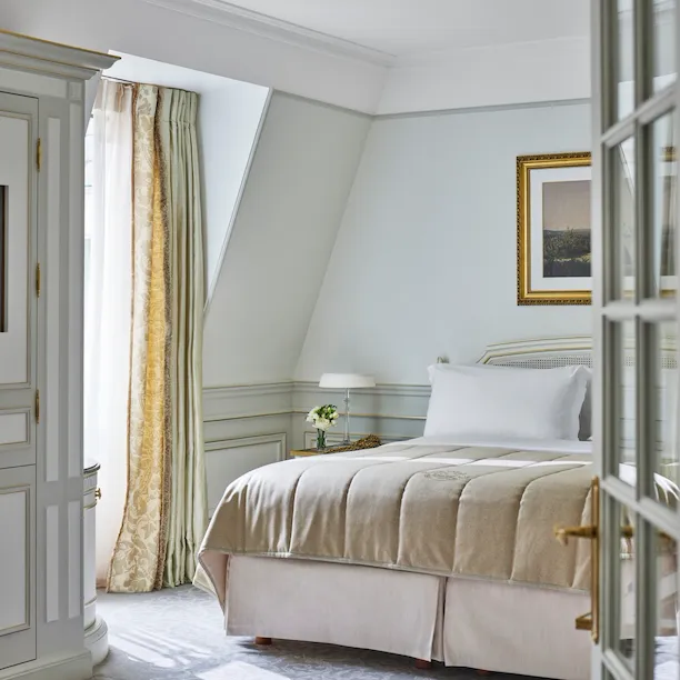 Chambre d'une suite junior aux tons vert clair et beige au Meurice, Paris.