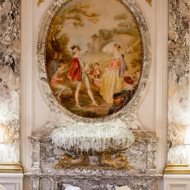 Portrait de la sculpture murale en verre avec des tables dressées de chaque côté au Restaurant Le Meurice Alain Ducasse, au Meurice, Paris.
