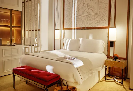 Bedroom of prestige room, headboard with peacocks illustration an mirrored wardrobe, at Hotel Eden, Rome