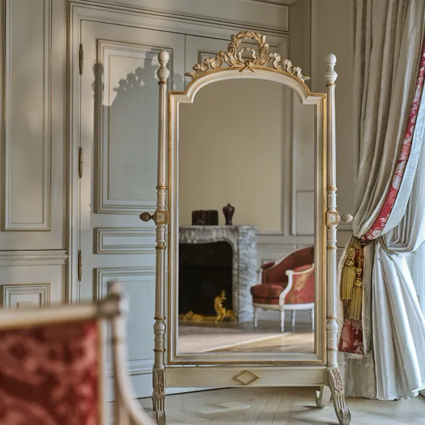 Reflect on the mirror, of the Presidential Suite Dali, of the chair next to the fireplace with decorations on the top, at Le Meurice, Paris