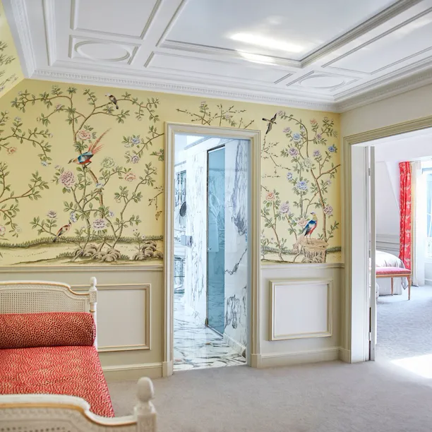 Salon avec un papier peint jaune avec des oiseaux et des éléments de la nature dessinés sur elle, dans une suite junior exécutive à Le Meurice, Paris.