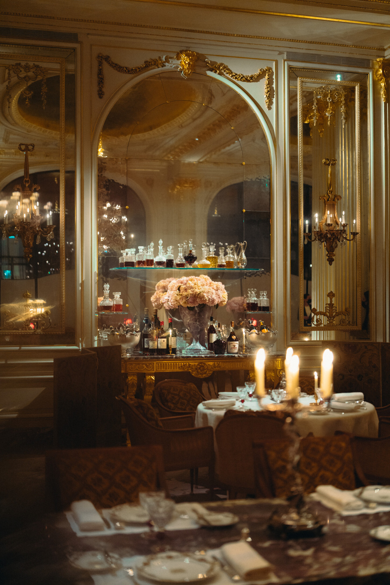 Overview of the Jean Imbert au Plaza Athénée Rafraichissoir, softened light and lighted candles at the forefront. At Hotel Plaza Athénée, Paris