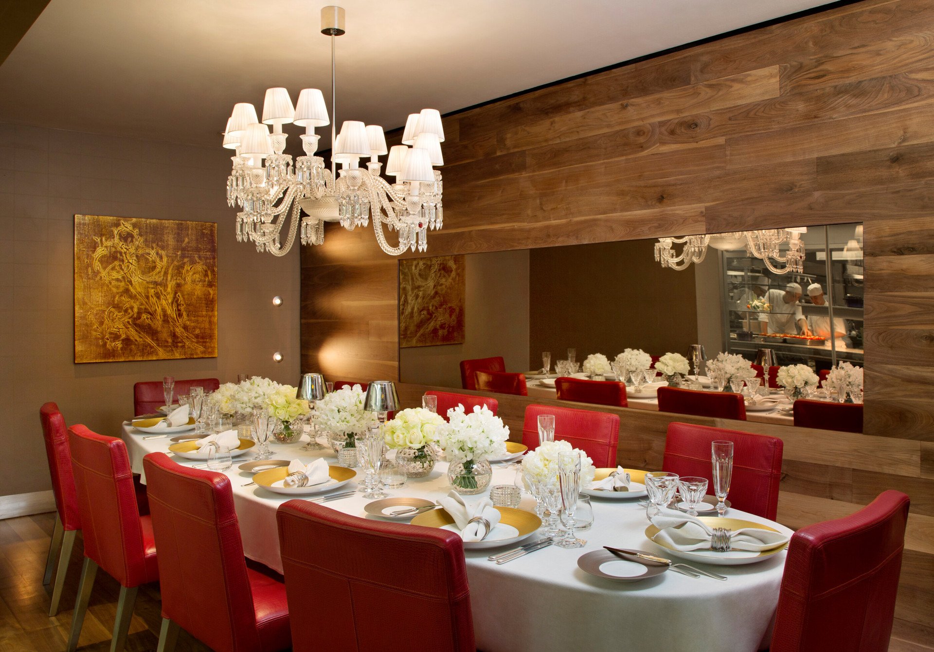 Chef's table set for 10 people with gold and white arrangments. 