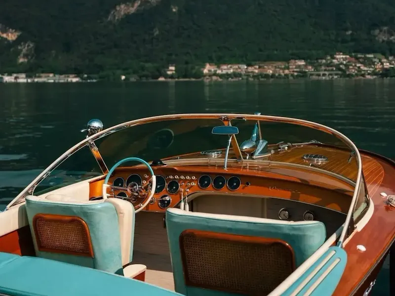 Riva boat in the foreground on Lake Iseo, with the shores and hills in the background.