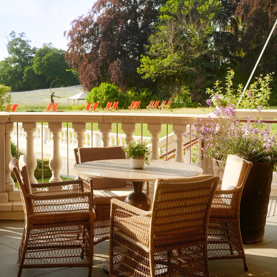 Coworth Park Drawing Room Terrace tables in afternoon sunshine overlooking grass fields