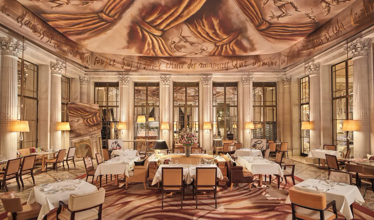 Large view on the restaurant Le Dali with all the dining furnitures, the mirror, the carpet and the painting on the ceiling, at Le Meurice, Paris
