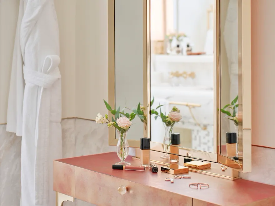 Toletta con specchio e oggetti di make up e gioielli in un bagno di una suite a Hotel Eden Roma