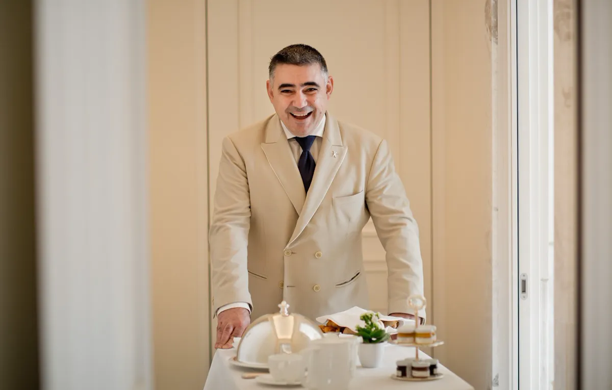 Portrait of waiter carrying in room dining cart at Hotel Eden, Rome
