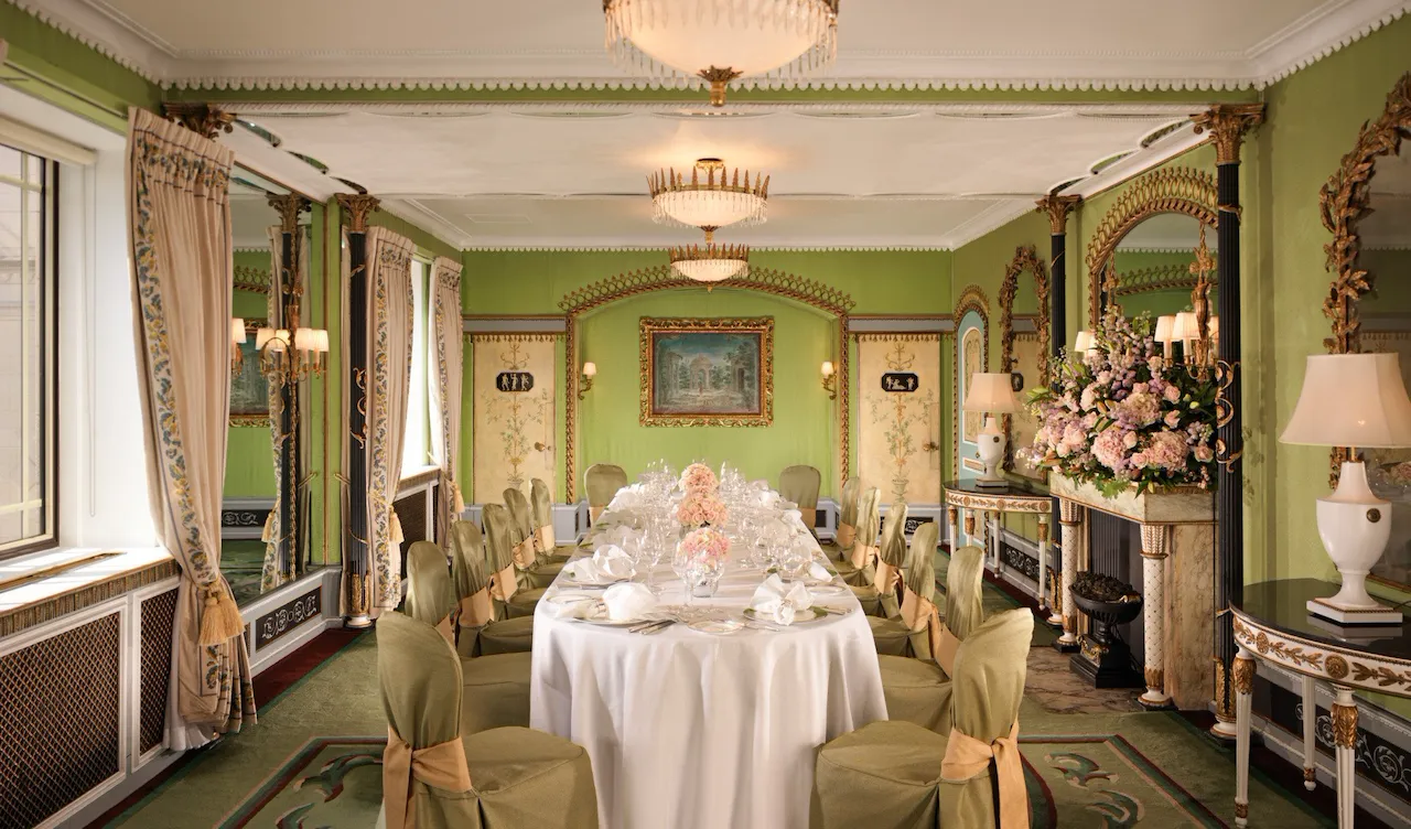 The Penthouse at The Dorchester for a social event dinner table set up - pink florals on the table and green walls in the room
