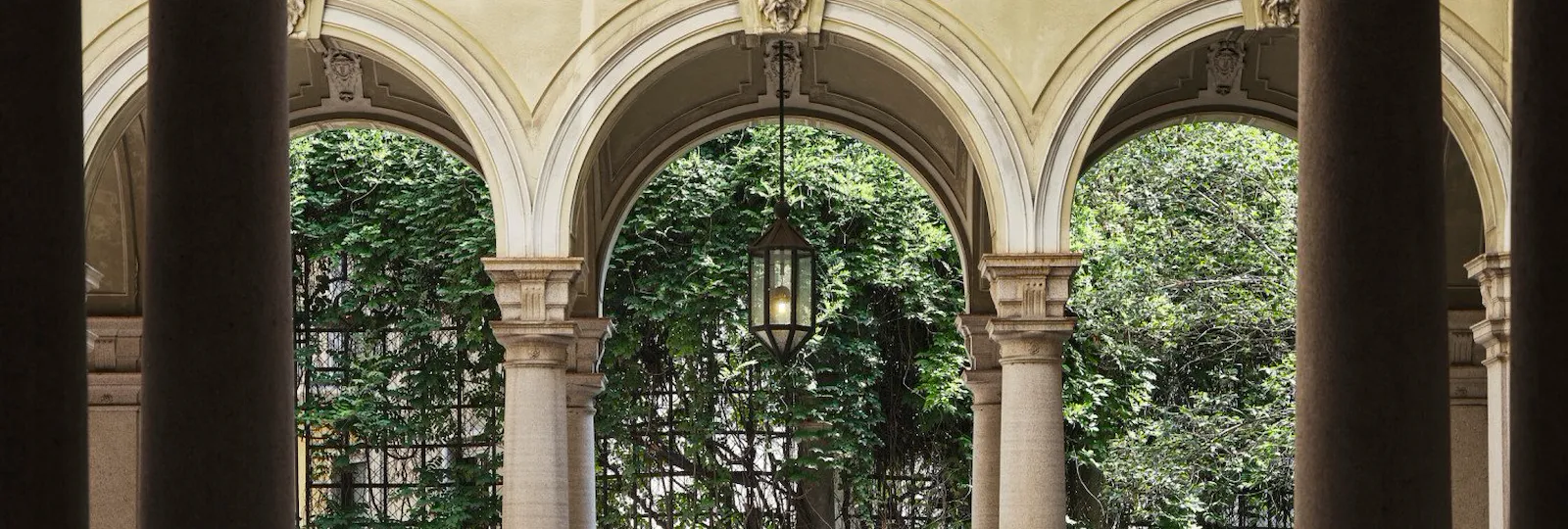 Un cortile del quartiere di Brera con archi e piante