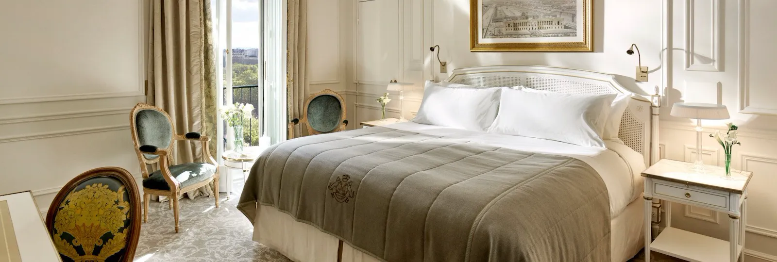 Vue d’ensemble d’une chambre exécutive mettant en valeur les tons gris clair et crème, ainsi que la vue sur les jardins des Tuileries en arrière-plan. Au Meurice, à Paris.