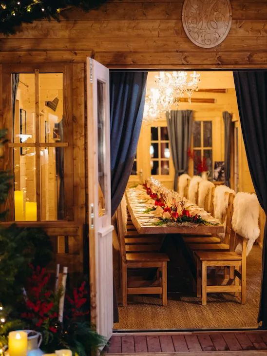 Le Chalet du Plaza Athenee showing en open door to a dressed wooden table and chairs