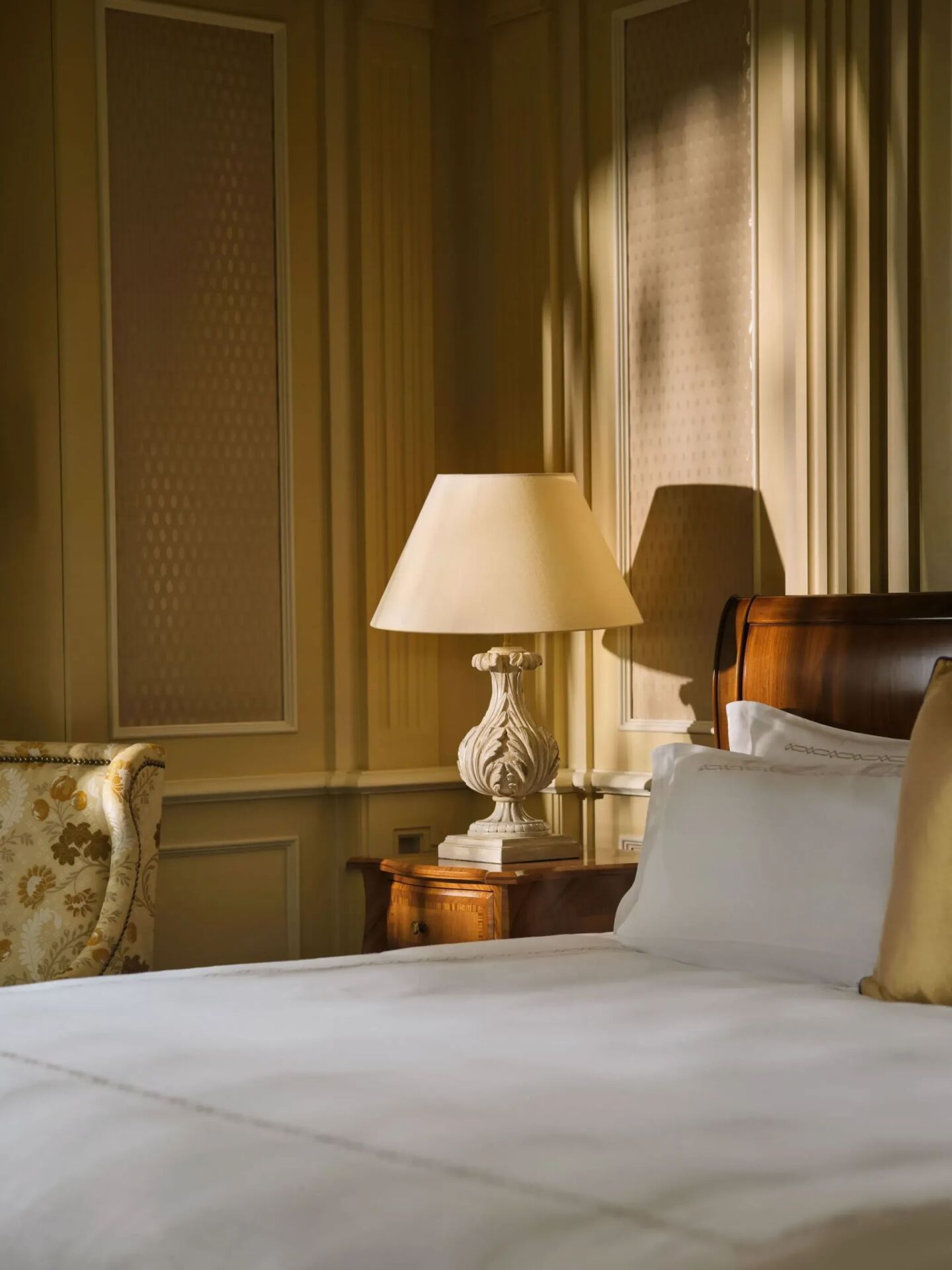 Classic room with soft cream and gold colors, wood details and bedside lamps