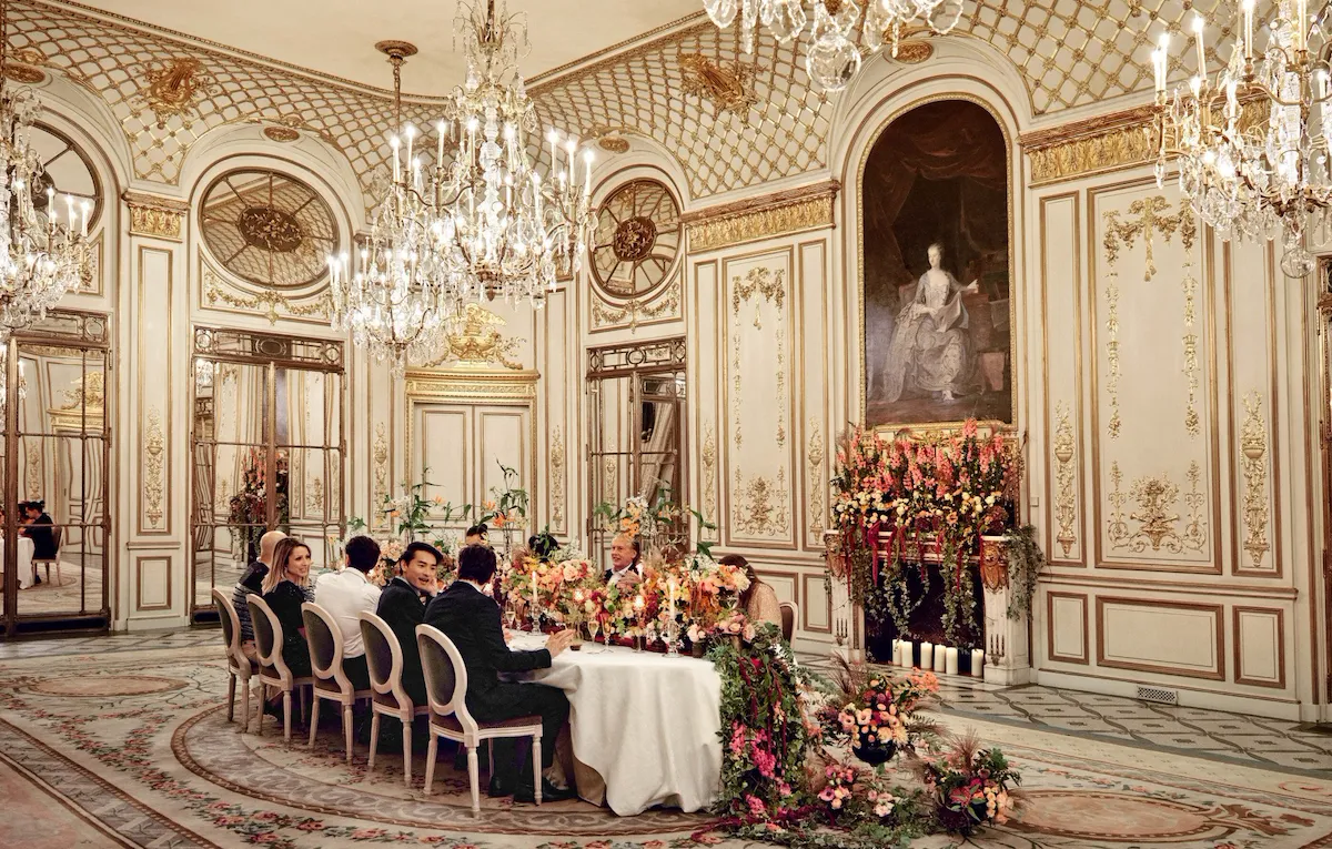Vue plan large d’un dîner au Salon Pompadour avec de personnes qui discutent à table au Meurice, Paris - Dorchester Collection