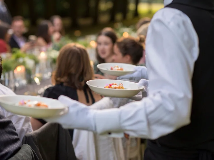 A waiter carrying dishes at event to serve guest