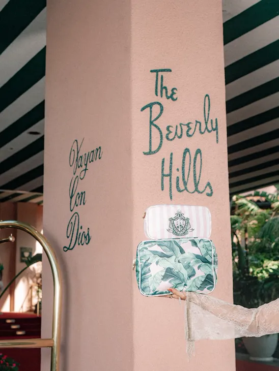 A person points to a sign for Beverly Hills on a pillar inside a decorated indoor space.
