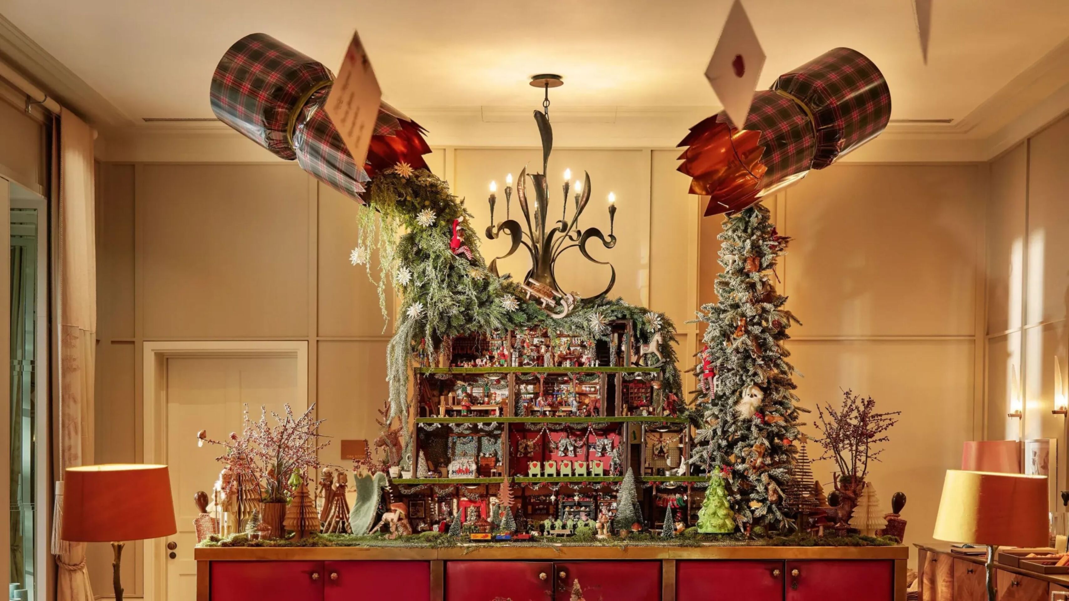 The Lobby at Cworth Pak is in the afternoon light with festive decorations and a doll house on the back of the reception desk. The doll house is full of small festive scenes like a Christmas dinner with nutcrackers and a raging fireplace with mince pies.