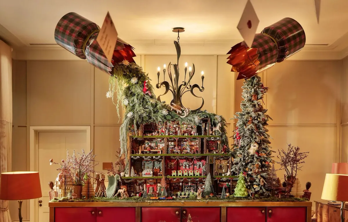 The Lobby at Cworth Pak is in the afternoon light with festive decorations and a doll house on the back of the reception desk. The doll house is full of small festive scenes like a Christmas dinner with nutcrackers and a raging fireplace with mince pies.