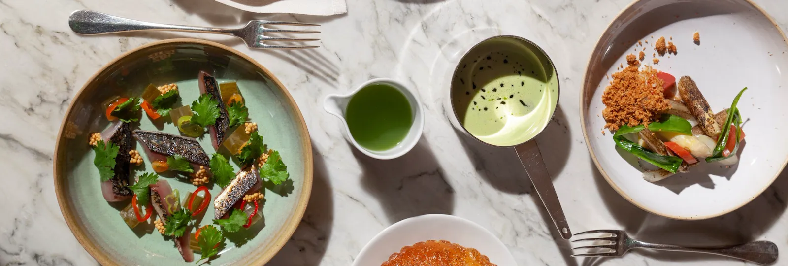 Aerial view of 3 starters with sauces and bread on the side at Restaurant le Dali at Le Meurice, Paris.
