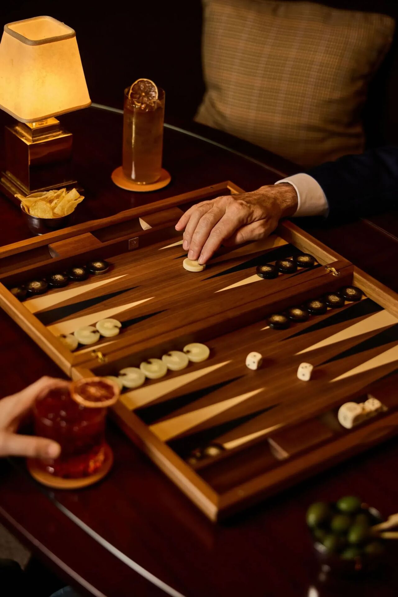 two men playing Backgammon at Principe Bar with cocktails and chips on the table