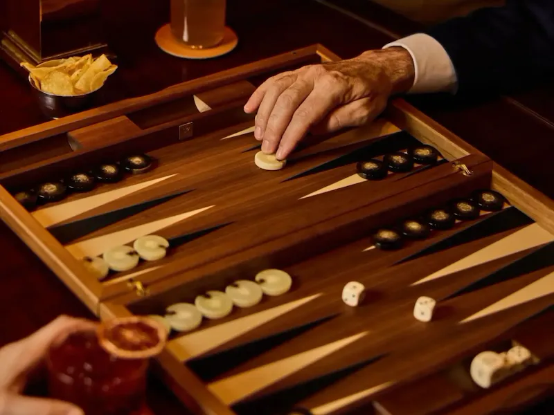 two men playing Backgammon at Principe Bar with cocktails and chips on the table