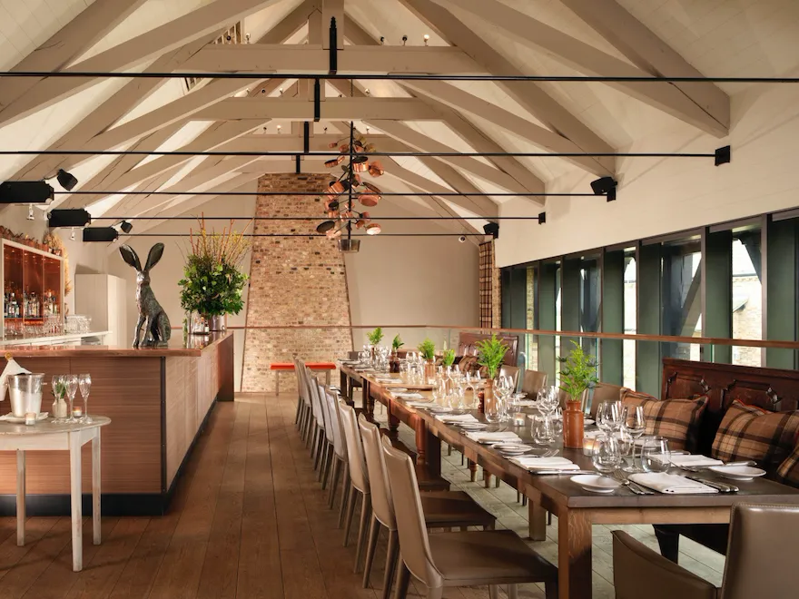 Barn indoors, long set up table on the right and bar corner in sight on the left