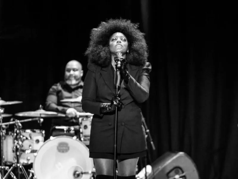 The Dorchester The Promenade Christmas Concert with Mica Paris - Black and white image of singer Mica Paris standing in front of a microphone on stage
