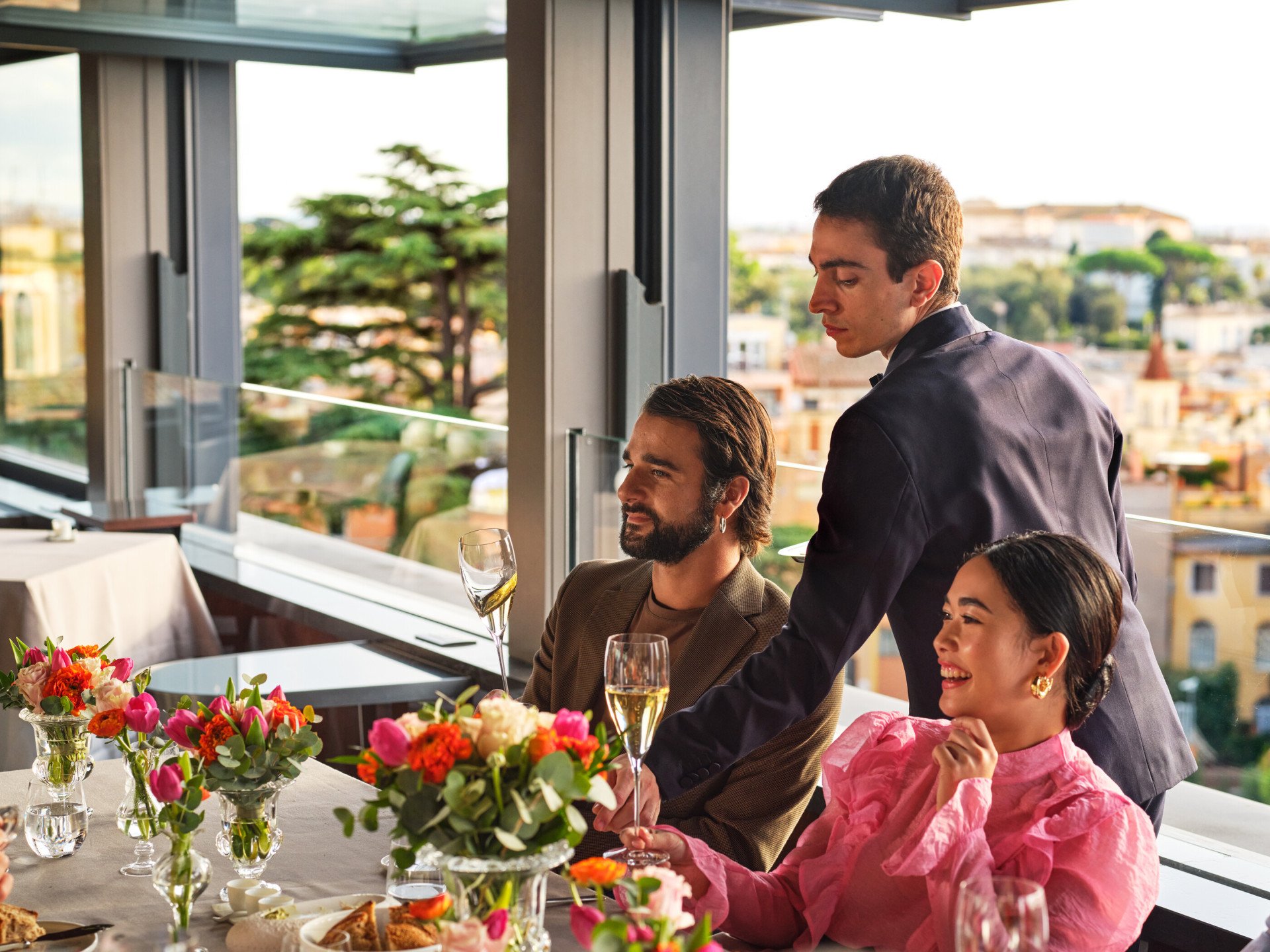 Cameriere che serve champagne a una coppia 