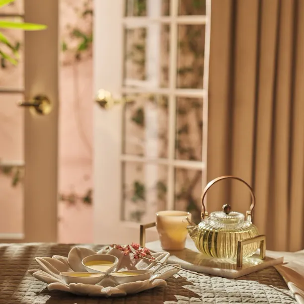 treatment oils on bed with tea set-up moment