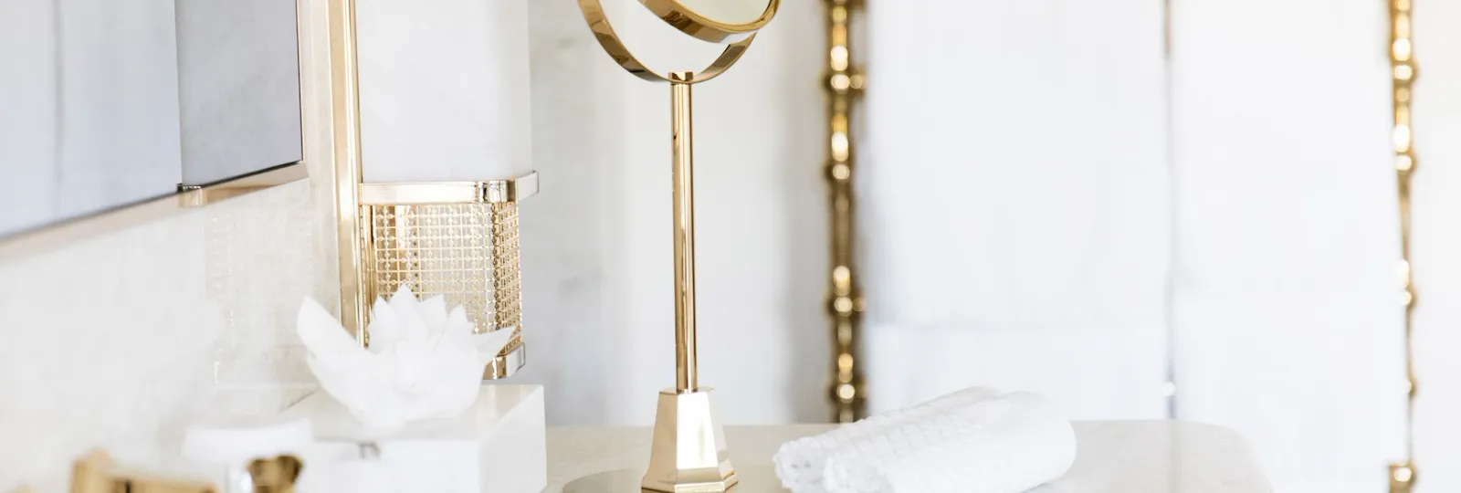 Bathroom detail with vanity mirror, towels and white marble sink at Hotel Eden, Rome
