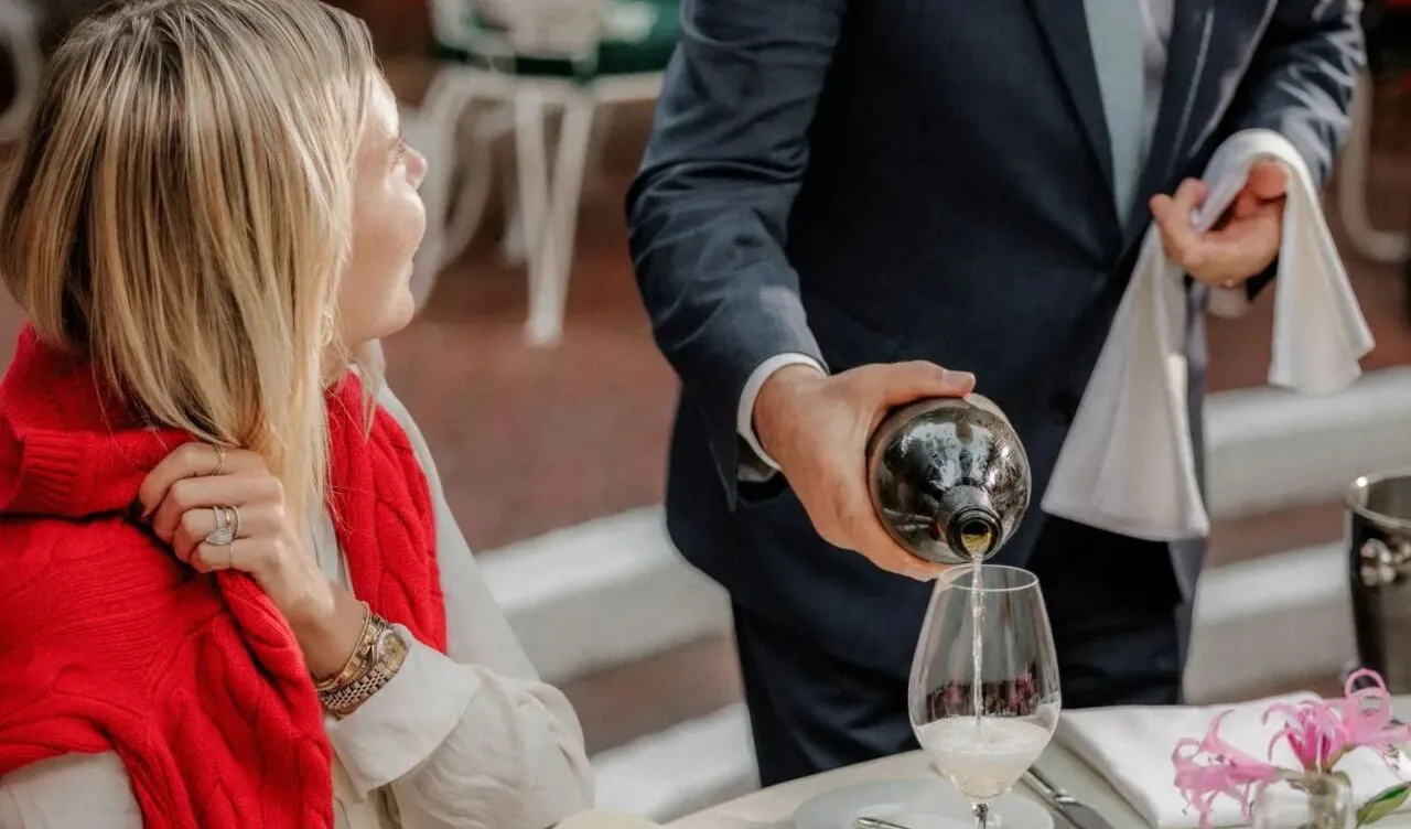 Pepe pouring wine on Polo Lounge patio during festive season