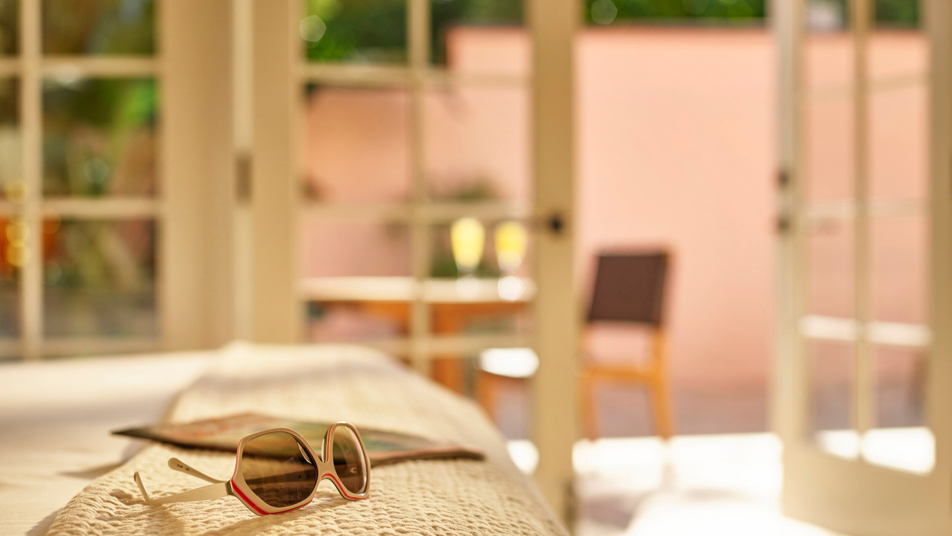 Sunglasses on bed of luxurious suite in Hotel Bel-Air