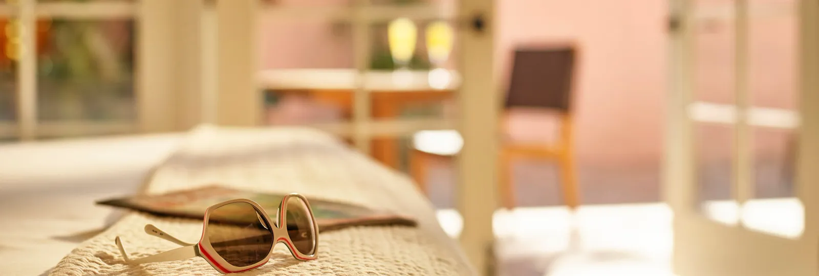 Sunglasses on bed of luxurious suite in Hotel Bel-Air
