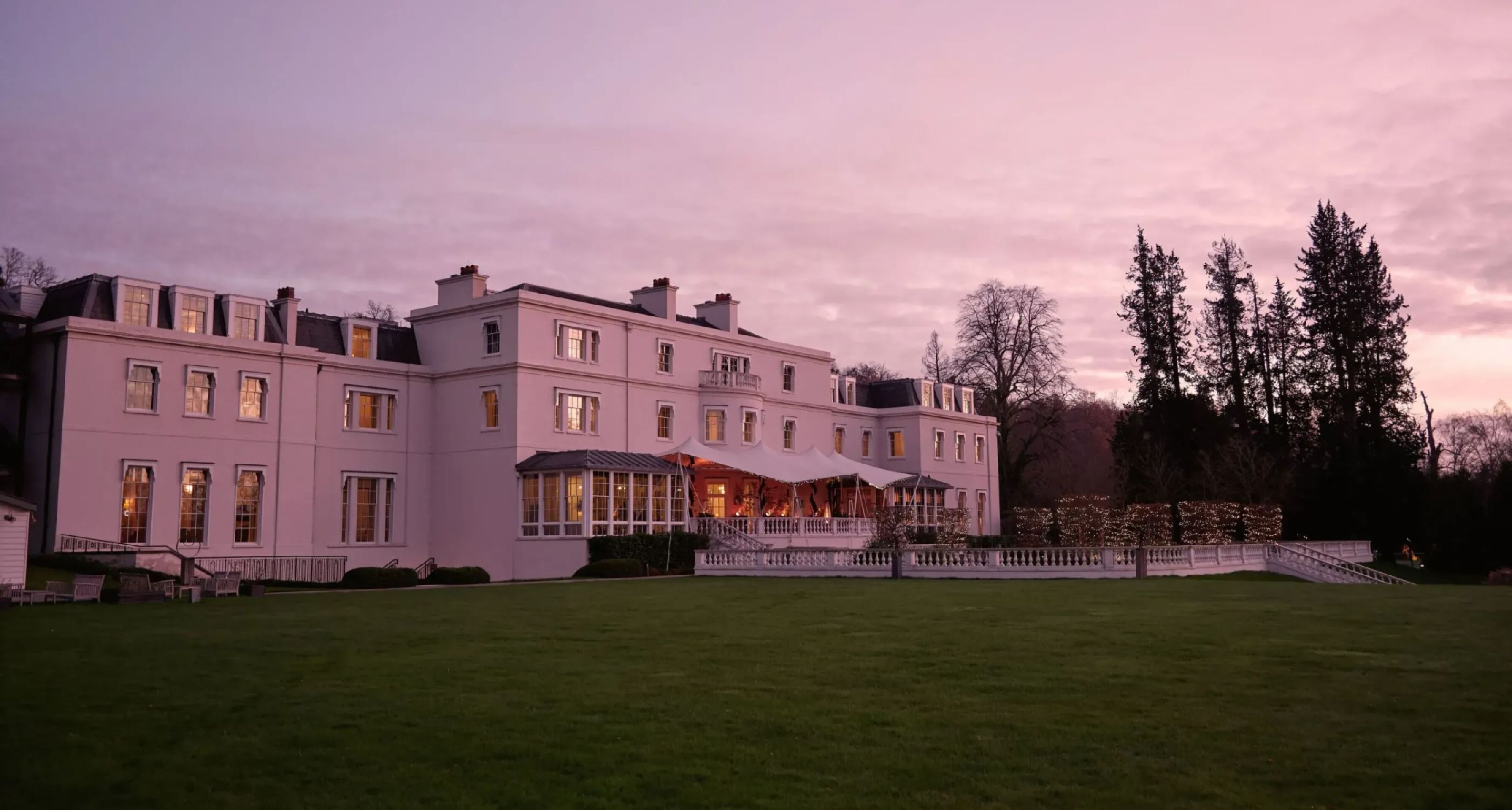 The exterior of the Mansion House at Coworth Park in the evening light 