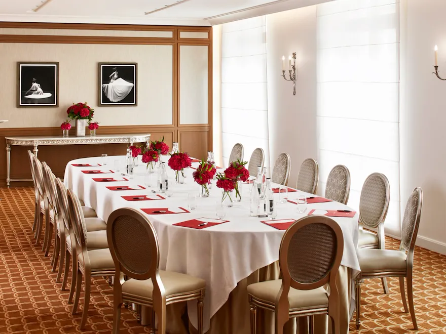 Sala criativa com uma mesa de reuniões oval decorada com flores e equipamento de escrita