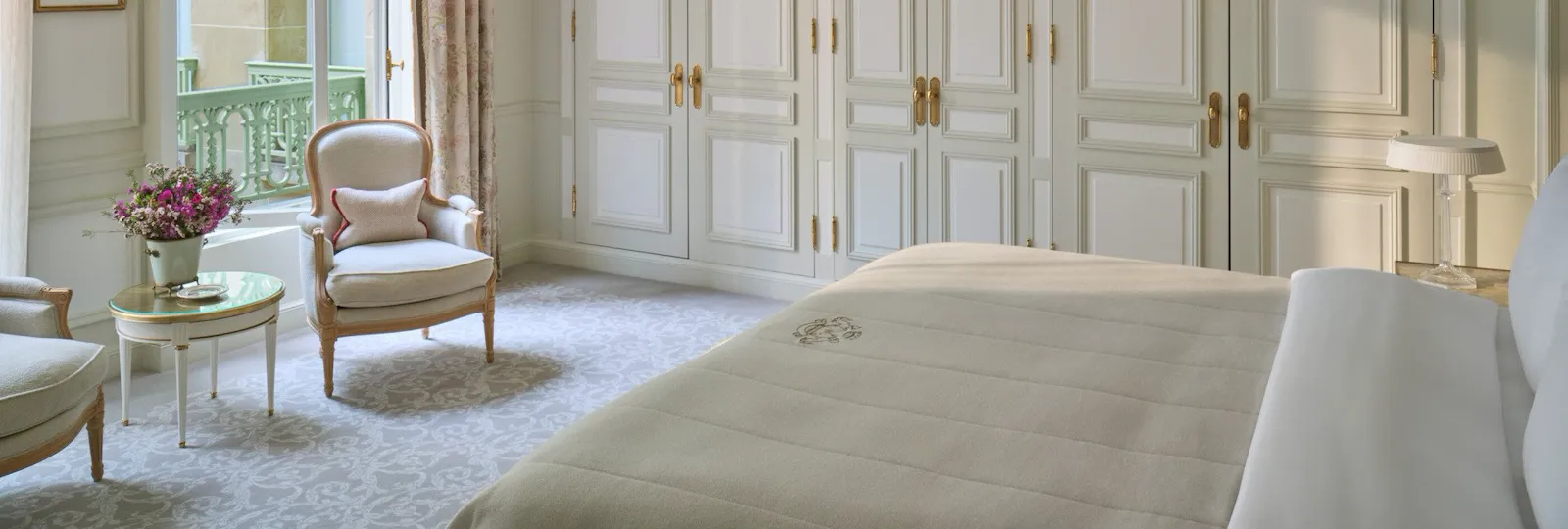 View from the left of an executive room with the bed in front of the chairs and the windows, at Le Meurice, Paris