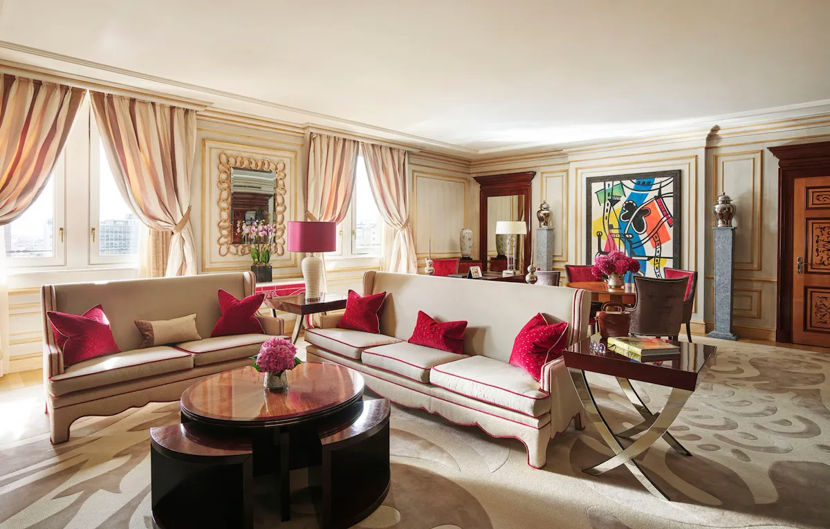 Soggiorno della Imperial Executive Suite arredato con divani bianchi in primo piano e opere d'arte colorate sullo sfondo