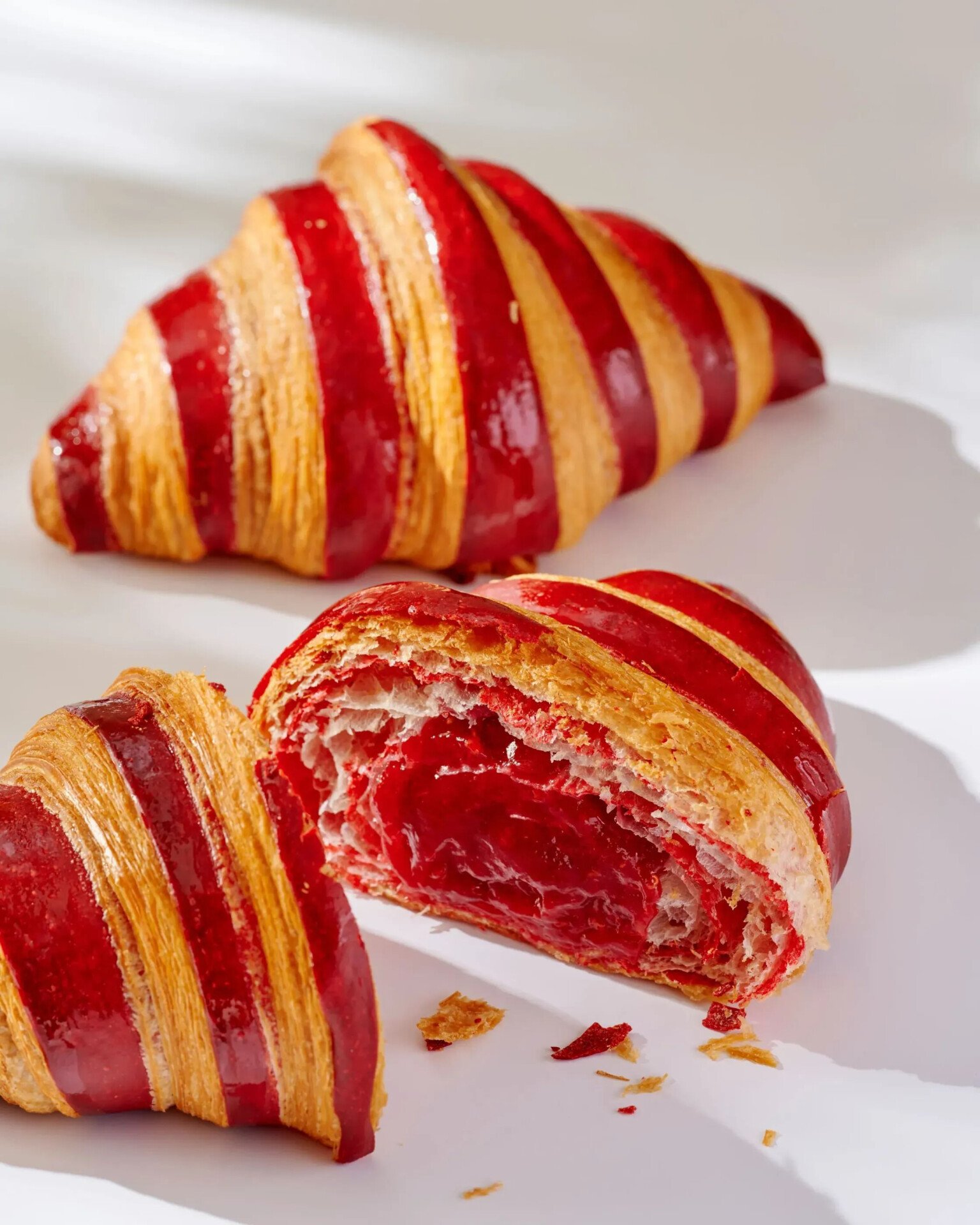 Pastry, viennoiseries and beverage offering at Bonbon Café Angelo Musa infront of a white backdrop with shadows.