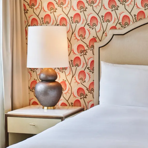 Corner of bed and deskside table in Bungalow Patio Room, The Beverly Hills Hotel