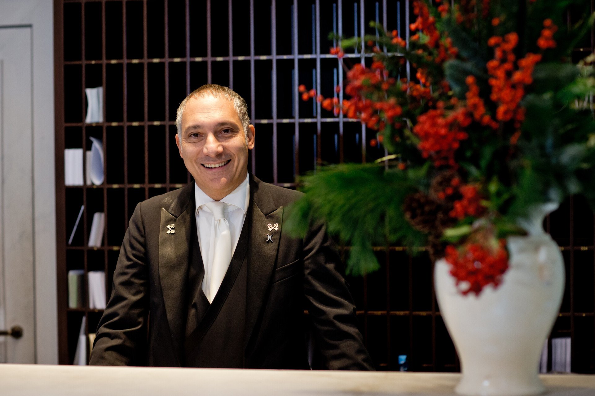 Smiling concierge standing behind his desk at Hotel eden