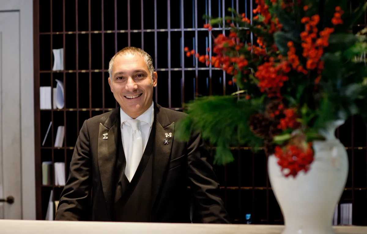 Smiling concierge standing behind his desk at Hotel eden