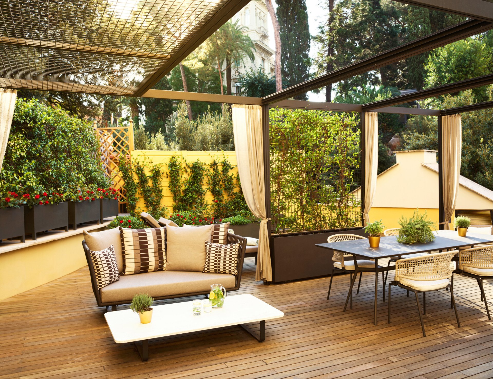 Sunny terrace with couch, dining table and chairs at Aurora Terrace Suite at Hotel Eden, Rome