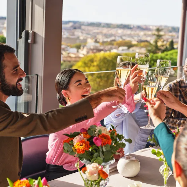 Gruppo di persone sedute ad un tavolo de La Terrazza con i calici alzati per un brindisi