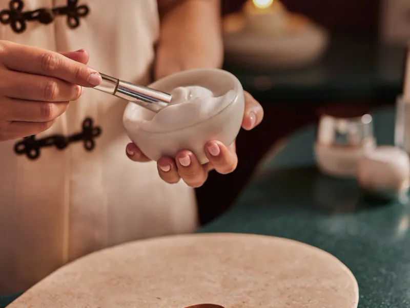 spa attendant preparing massage supplies