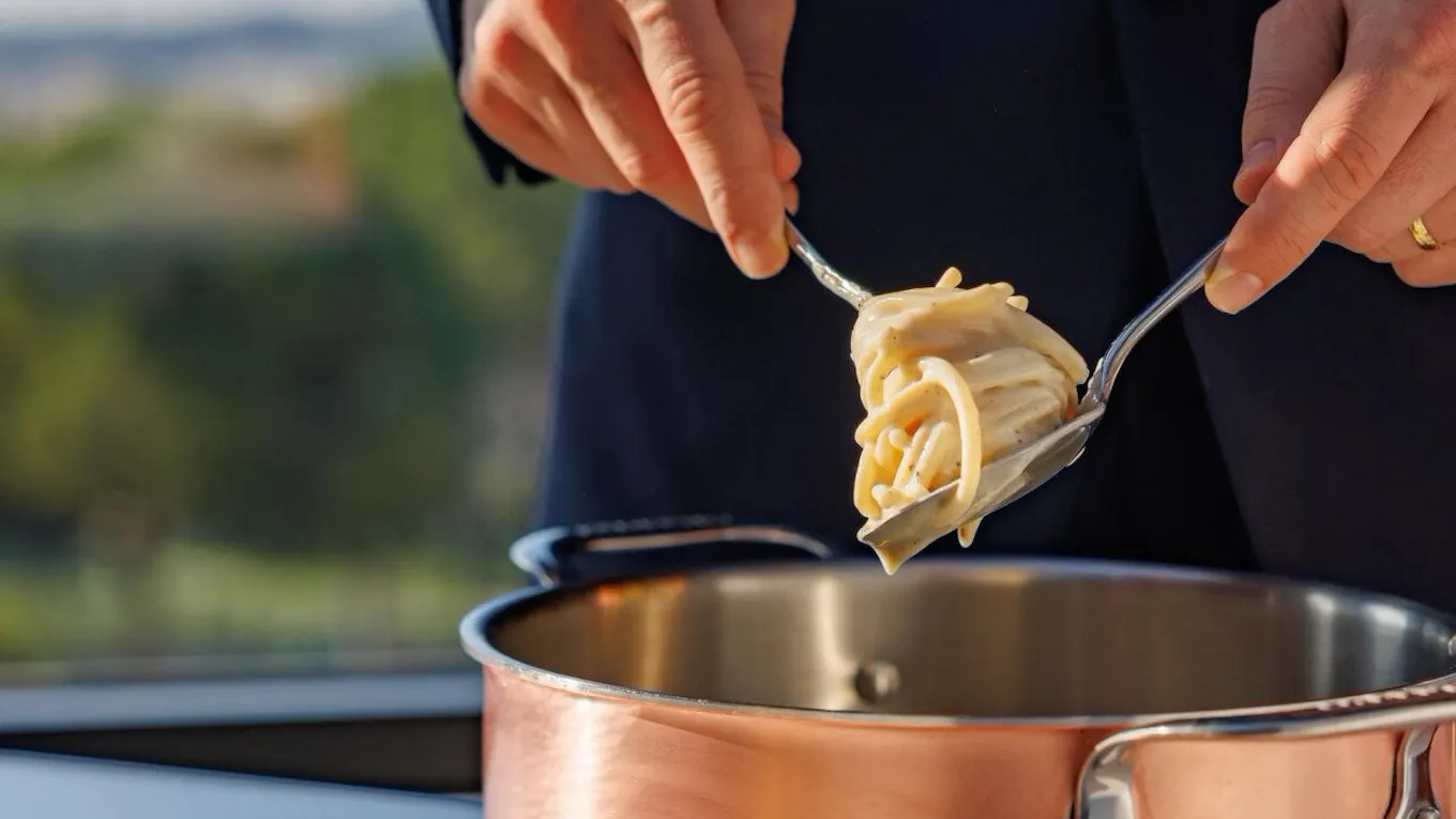 Spaghetti cacio e pepe serviti al tavolo da una pentola di rame a Il Giardino Ristorante