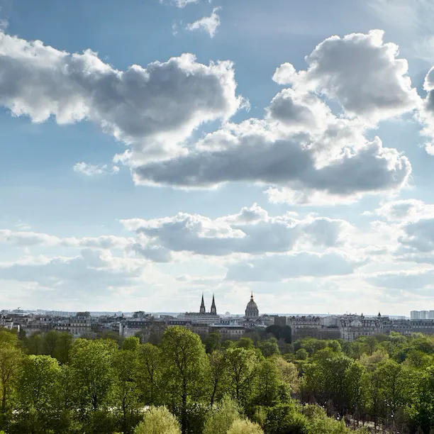 Vue depuis une chambre exécutive côté parc, avec le jardin des Tuileries, et la ville en arrière-plan. Au Meurice, Paris.